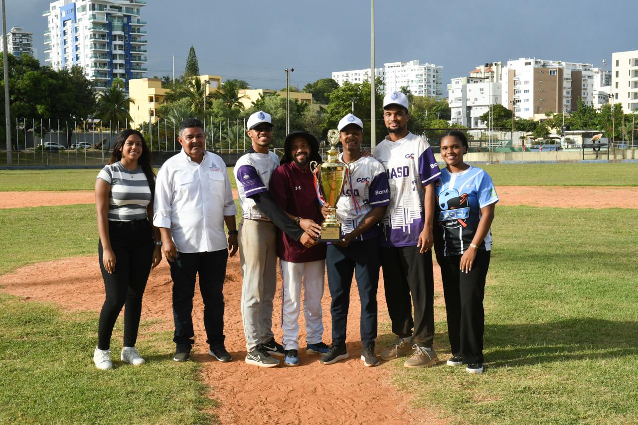 Dirigentes, jugadores y la madrina de la UASD posan con el trofeo de campeón el que conquistaron tras vencer a Unapec.