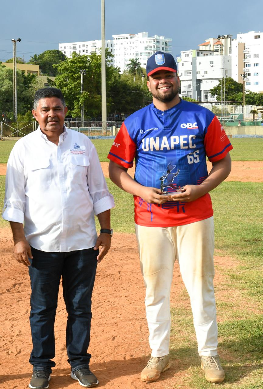Diógenes De la Cruz, asistente del Comisionado de Béisbol Junior Noboa, hace entrega del trofeo a Willger De Jesús, dirigente campeón de la UASD.