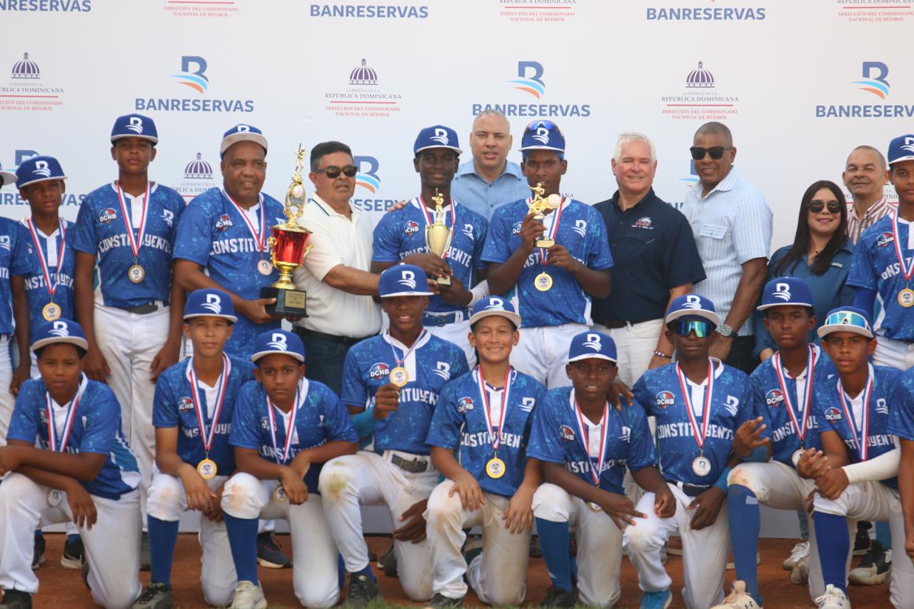 El equipo de Los Constituyentes reciben la Copa Banreservas que los acredita como campeones de la Copa Infantil U12. Les acompañan Abraham Kay, Diógenes De La Cruz, Eugenio Báez.